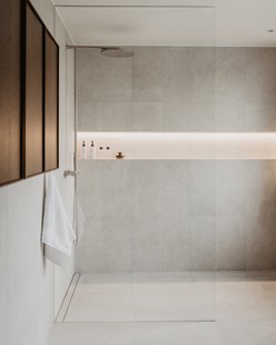 Duschvägg från golv till tak med belyst duschhylla